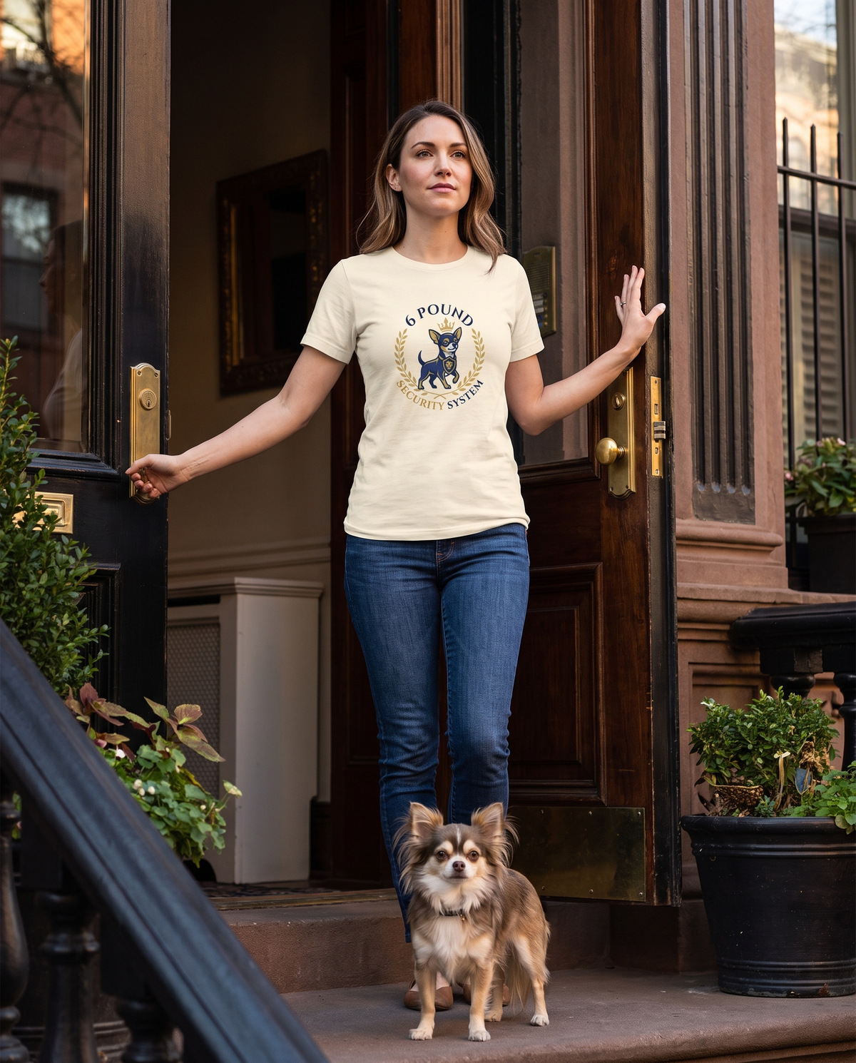 Woman wearing the 6-Pound Security System chihuahua t-shirt in a doorway with her chihuahua on guard