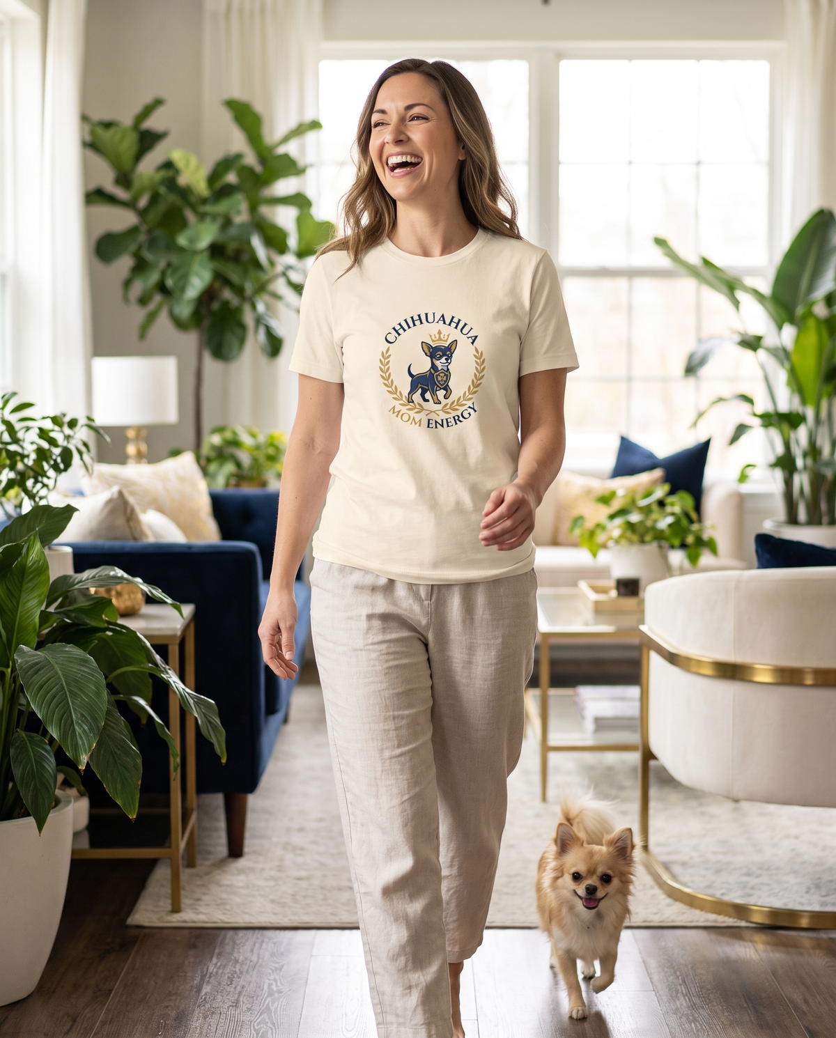 Woman wearing the Chihuahua Mom Energy t-shirt at home with her chihuahua