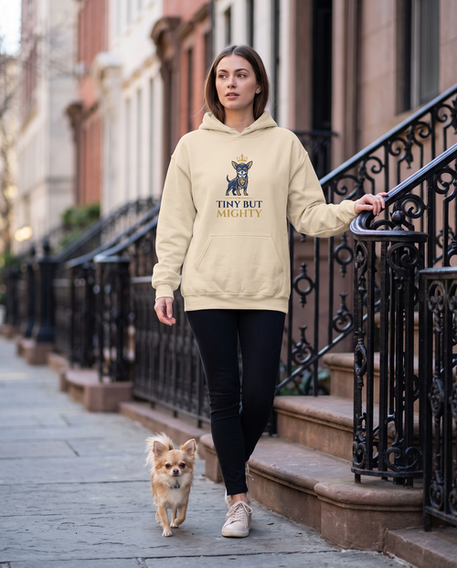 Woman wearing the Tiny But Mighty chihuahua hoodie on townhouse steps with her chihuahua